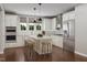 Bright kitchen with white cabinets, stainless steel appliances, large kitchen island, and three stools at 2007 Trident Maple Ln, Chapel Hill, NC 27517