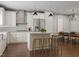 Open-concept kitchen with white cabinets, an island with seating, and stainless steel appliances at 2007 Trident Maple Ln, Chapel Hill, NC 27517