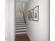 Bright stairway features hardwood floors, white walls, and artwork enhancing the tall ceilings at 2007 Trident Maple Ln, Chapel Hill, NC 27517