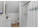 Loft bathroom with wood-look flooring, shower with curtain and a simple white vanity at 211 Fleming Dr, Durham, NC 27712