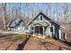 View of home and detached garage, featuring light green siding and neutral trim at 211 Fleming Dr, Durham, NC 27712