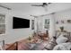 Bright living area with a large flat screen TV, patterned rug, and two chairs surrounding a glass table at 211 Fleming Dr, Durham, NC 27712