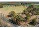 Aerial view of the property nestled amidst trees, fields, and a nearby road at 2125 W Academy St, Holly Springs, NC 27540