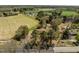 Wide aerial view showcasing the home's rural setting with fields and distant buildings at 2125 W Academy St, Holly Springs, NC 27540