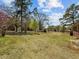 Spacious back yard featuring mature trees, open green space, and a shed at 2125 W Academy St, Holly Springs, NC 27540