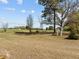 Expansive back yard featuring mature trees, open green space, and view of the agricultural field at 2125 W Academy St, Holly Springs, NC 27540
