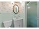 Bathroom with ornate lighting, oval mirror, and light-green vintage tile and wallpaper at 2125 W Academy St, Holly Springs, NC 27540