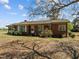 Exterior shot of a brick house with a screened porch and an unpaved yard at 2125 W Academy St, Holly Springs, NC 27540
