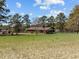 Charming brick home with mature trees and a sprawling green lawn at 2125 W Academy St, Holly Springs, NC 27540