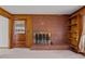 Brick fireplace with hearth and gold screen, accompanied by wood-paneled walls and a wooden door at 2125 W Academy St, Holly Springs, NC 27540