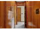 Hallway with wood-paneled walls, vintage telephone, and multiple doorways at 2125 W Academy St, Holly Springs, NC 27540