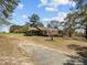 Charming brick home with a screened-in porch and gravel driveway at 2125 W Academy St, Holly Springs, NC 27540