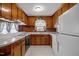 The kitchen features wood cabinets, white countertops and white appliances at 2125 W Academy St, Holly Springs, NC 27540