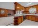 A kitchen with wooden cabinets, white countertops and a view to the living room with fireplace at 2125 W Academy St, Holly Springs, NC 27540