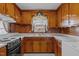 A kitchen with wood cabinets, a window above the sink and electric stove at 2125 W Academy St, Holly Springs, NC 27540