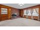 Spacious living room with a brick fireplace, built-in shelving, and multiple windows with curtains at 2125 W Academy St, Holly Springs, NC 27540