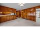 Cozy living room featuring wood paneling, a kitchen pass-through, and soft neutral carpet at 2125 W Academy St, Holly Springs, NC 27540