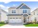 Charming two-story home featuring a two-car garage, and a welcoming front porch with a rocking chair at 2177 Campbell, Burlington, NC 27215