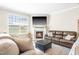 Bright living room with a fireplace, large windows, comfortable seating, and neutral decor at 2177 Campbell, Burlington, NC 27215