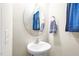 Clean powder room with a pedestal sink, an oval mirror, and blue decorative towels at 2177 Campbell, Burlington, NC 27215