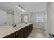 Spacious primary bathroom with double sinks, dark wood cabinets, tile floors and a large mirror at 2310 Gilman St, Durham, NC 27703