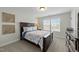 Bedroom featuring a dark wood queen bed, side table and window with natural light and blinds at 2310 Gilman St, Durham, NC 27703