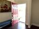 Open red door leading to a view of the front yard, bench, and hardwood flooring at 2310 Gilman St, Durham, NC 27703