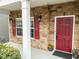 Close-up of the red front door with stone accents and a white support column at 2310 Gilman St, Durham, NC 27703
