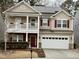 Charming two-story home with a red door, red shutters, a second story balcony, and a two car garage at 2310 Gilman St, Durham, NC 27703