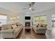Cozy living room with sofas, fireplace, hardwood floors, a modern ceiling fan and natural light from the window at 2310 Gilman St, Durham, NC 27703