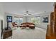 Spacious living room with tan carpet, neutral walls, three windows, ceiling fan and a leather couch at 2310 Gilman St, Durham, NC 27703