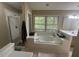 Bright bathroom featuring a soaking tub with jets, and a glass shower at 27 Creeks Edge Ct, Durham, NC 27713