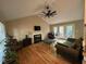 Open living room with hardwood floors, a fireplace, a ceiling fan, and French doors at 27 Creeks Edge Ct, Durham, NC 27713