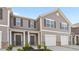 Charming townhome featuring gray siding, white trim, a garage, and a welcoming front porch at 2836 Egert Dr, Haw River, NC 27258