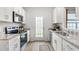 Well-lit kitchen featuring granite countertops, stainless steel appliances, and ample cabinet space at 2836 Egert Dr, Haw River, NC 27258