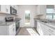 Well-lit kitchen with stainless steel appliances, stone countertops, white cabinets, and a modern backsplash at 2838 Egert Dr, Haw River, NC 27258
