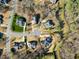 A high-angle aerial view of several luxury homes on a street, surrounded by trees and manicured lawns at 3 Alumwood Pl, Durham, NC 27705