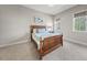 Bedroom with hardwood bed frame and views from its many windows at 3 Alumwood Pl, Durham, NC 27705