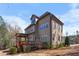Side view of home showcasing its architecture, deck, and well-maintained landscaping in a wooded setting at 3 Alumwood Pl, Durham, NC 27705