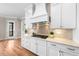 Bright kitchen features white cabinetry, granite counters, and a stylish tile backsplash at 3 Alumwood Pl, Durham, NC 27705