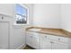 The laundry room features a sink and white cabinets for storage at 3 Alumwood Pl, Durham, NC 27705