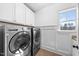 Well-equipped laundry room features a washer, dryer, and storage cabinets at 3 Alumwood Pl, Durham, NC 27705