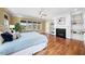 Bright main bedroom features a fireplace, built-in shelving, and hardwood floors at 3 Alumwood Pl, Durham, NC 27705