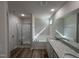 Bright bathroom featuring a dual sink vanity, tub, and glass-enclosed shower at 325 Magnolia Run Way, Benson, NC 27504