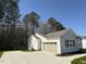 Side view of a single-story home featuring an attached garage and a concrete driveway at 325 Magnolia Run Way, Benson, NC 27504