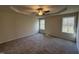Spacious main bedroom featuring carpet floors, a tray ceiling, and a ceiling fan at 325 Magnolia Run Way, Benson, NC 27504