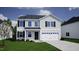 Inviting two-story home featuring a clean white garage door and complementary shutters under a partly cloudy blue sky at 35 Calabria Ct, Franklinton, NC 27525