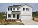 Charming two-story home with black shutters, white siding, a two-car garage, and a well-manicured lawn at 35 Calabria Ct, Franklinton, NC 27525