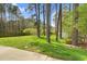 Expansive backyard with lush green lawn, bordered by mature trees and a charming wooden fence at 3910 Hillgrand Dr, Durham, NC 27705