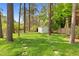 Lush backyard featuring a storage shed and mature trees offering privacy at 3910 Hillgrand Dr, Durham, NC 27705